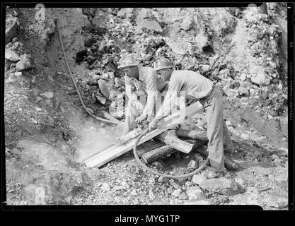 Arthur Roberts et Sam Mynatt, le forage d'une tourné en boulder de chaussée à Norris Dam. - Banque D'Images