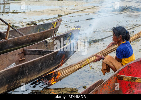 1 mai 2018 - L'archipel de Myeik, Myanmar. Femme Moken câblages canoe on beach Banque D'Images