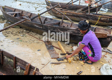 1 mai 2018 - L'archipel de Myeik, Myanmar. Femme Moken câblages canoe on beach Banque D'Images