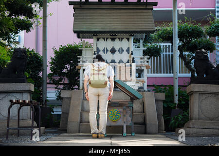 Tokyo, Japon - 22 juillet 2017 : femme en prière dans le sanctuaire de culte Sui dans marché Tsukiji. Banque D'Images