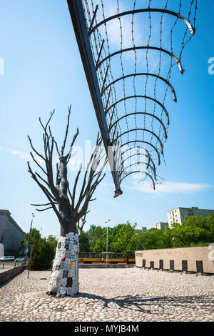 Pawiak à Varsovie, vue d'une section de fil de fer barbelé et passerelle d'origine de l'arbre commémoratif à l'entrée du musée de la prison Pawiak à Varsovie, Pologne. Banque D'Images