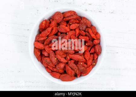 Les baies de Goji Berry de bol au-dessus de bois bois Banque D'Images