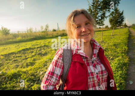 Close up portrait of happy plus femme debout à l'extérieur en été sur l'arrière-plan sur le terrain. Banque D'Images