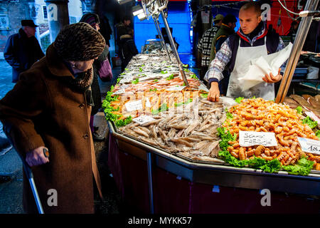 Une femme âgée d'acheter du poisson frais du marché, Venise, Italie Banque D'Images