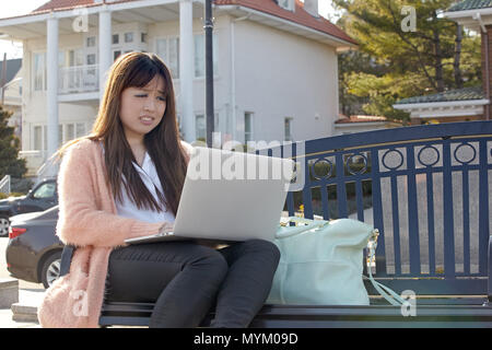 Asian woman working on laptop computer Banque D'Images