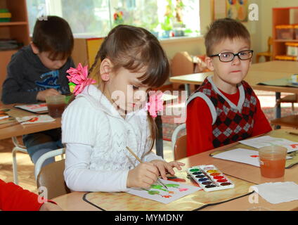 Leçon de dessin en maternelle. Les peintures de fille sur papier. Banque D'Images