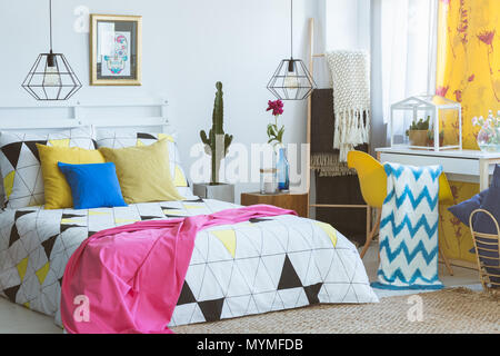 Chambre colorée avec un fauteuil jaune et verre terrarium avec cactus Banque D'Images