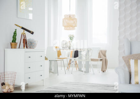 Loft blanc intérieur avec commode, table et chaises Banque D'Images