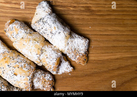 Les cookies avec un remplissage de pavot. Biscuits aux graines de pavot et de sucre en poudre. Cookies faits maison sur fond de bois Banque D'Images