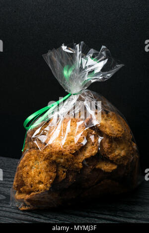 Les cookies faits maison dans le sac avec l'avoine, lin et graines de sésame sur table rustique en bois foncé, de copier l'espace. Les cookies vegan sain avec g Banque D'Images