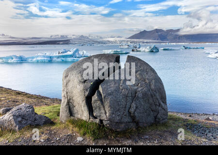 Split Rock et les icebergs flottant dans la Lagune glaciaire du Jökulsárlón Le Parc national du Vatnajökull en Islande Banque D'Images