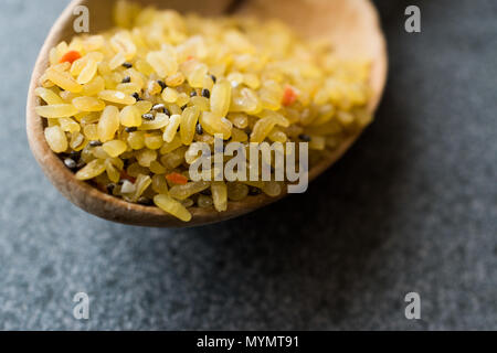 Matières premières non cuites avec du riz boulgour Chia Seeds en cuillère en bois / Boulgour pour Pilav ou Pilaf. L'alimentation biologique. Banque D'Images