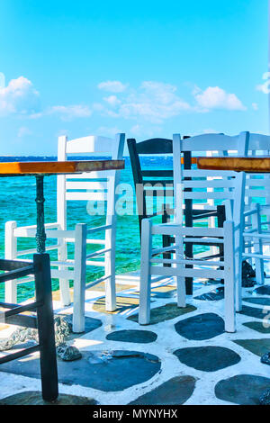 Cafe des tables et des chaises près de l'eau dans l'île de Mykonos, Grèce Banque D'Images