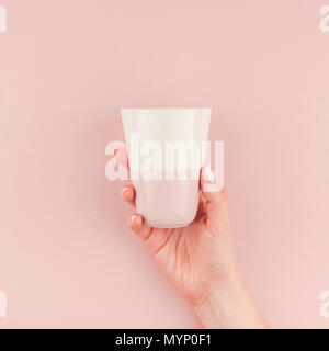 Creative Image de femme hand holding Coffee cup with copy space sur fond rose millénaire dans un style minimaliste. Concept2 modèle pour feminin Banque D'Images