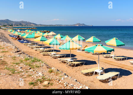 Des chaises longues avec parasols sur la plage de Kolymbia en journée ensoleillée. L'île de Rhodes, Grèce Banque D'Images