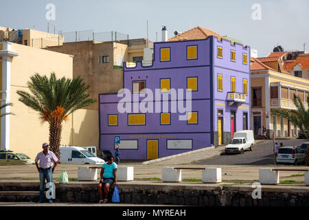 Bâtiment violet vibrant. Architecture colorée ville de Mindelo. Personnes en attente d'un transport à Mindelo, CAP VERT - Décembre 07, 2015 Banque D'Images