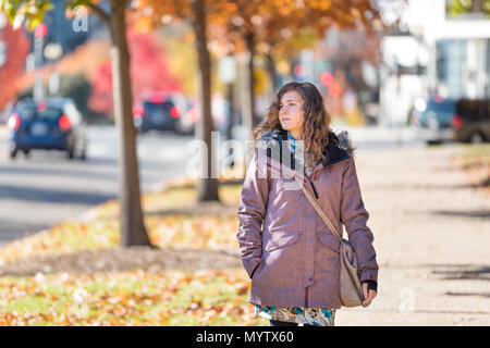 Young woman walking on sidewalk street à Washington DC, USA United States en allée de feuillage jaune orange or automne automne arbres sur route au cours de s Banque D'Images