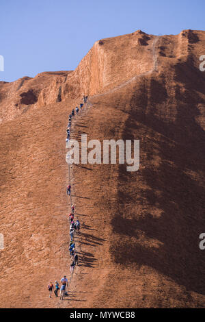 Marcher jusqu'Uluru, ou d'Ayer's Rock dans l'arrière-pays australien. La pratique est impopulaire auprès des propriétaires traditionnels de la terre et sera interdit en 2019 Banque D'Images