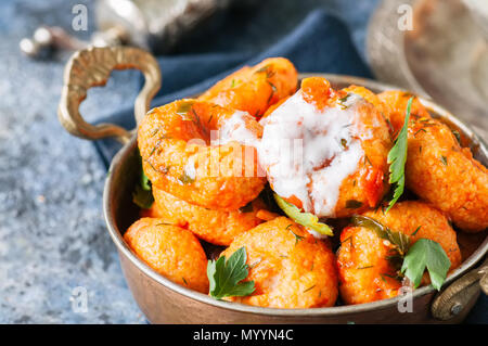 - Cuisine traditionnelle turque fellah koftes, polpettes de boulgour et de semoule en sauce tomate avec du persil et l'ayran. Middle Eastern food concept. Banque D'Images