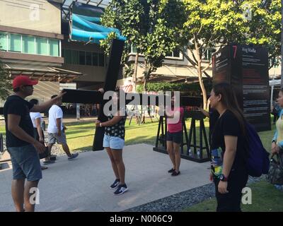 Taguig, Metro Manila, Philippines. 24Th Mar, 2016. Les citadins ont une chance de faire une croix sur le Jeudi Saint comme passerelle à Bonifacio High Street à Taguig City dispose d'une exposition interactive de revoir la mort et la résurrection de Jésus Christ. Sherbien Dacalanio : Crédit/StockimoNews/Alamy Live News Banque D'Images