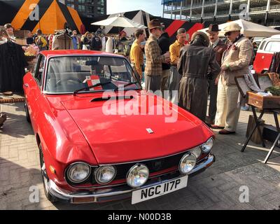 St stable, Londres, Royaume-Uni. Apr 23, 2017. Mode rétro shoppers alignés à côté d'une voiture Lancia rouge vintage au Classic Car Boot Sale dans le grenier Square, Kings Cross, Londres, Angleterre, Royaume-Uni. Dimanche 23 avril 2017. Crédit : Jamie Gladden/StockimoNews/Alamy Live News Banque D'Images