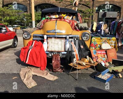 St stable, Londres, Royaume-Uni. Apr 23, 2017. Mode rétro Vêtements alignés à côté d'une voiture Chevrolet jaune vintage au Classic Car Boot Sale dans le grenier Square, Kings Cross, Londres, Angleterre, Royaume-Uni. Dimanche 23 avril 2017. Crédit : Jamie Gladden/StockimoNews/Alamy Live News Banque D'Images