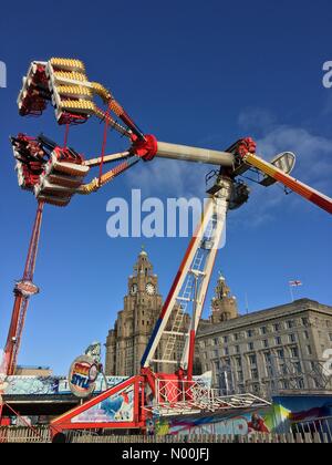 UK Météo : ensoleillé à Liverpool. Fête foraine en face des Trois Grâces ( foie et bâtiments Cunard) Banque D'Images