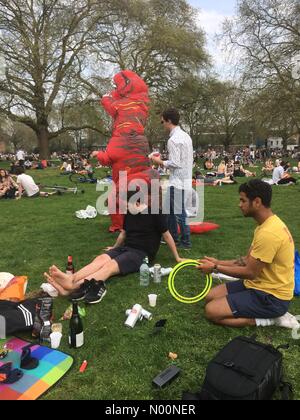 Londres, Royaume-Uni. 21 avril 2018. L'homme en costume avec des plaisanteries dinasour de personnes comme les Londoniens bénéficiant par temps chaud ensoleillé à Londres field Crédit : Emin Ozkan/StockimoNews/Alamy Live News Banque D'Images