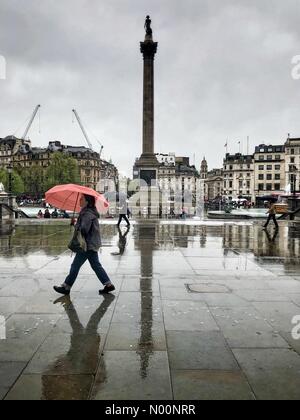 Londres, Royaume-Uni. Apr 30, 2018. Météo France : les touristes des parasols à pied grâce à Trafalgar Square, la Colonne Nelson se reflète sur la pluie sur la chaussée un sombre et pluvieuse après-midi de printemps à Londres, Angleterre, Royaume-Uni. Crédit : Jamie Gladden/StockimoNews/Alamy Live News Banque D'Images