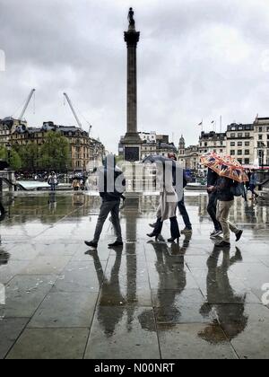 Londres, Royaume-Uni. Apr 30, 2018. Météo France : les touristes des parasols à pied grâce à Trafalgar Square, la Colonne Nelson se reflète sur la pluie sur la chaussée un sombre et pluvieuse après-midi de printemps à Londres, Angleterre, Royaume-Uni. Crédit : Jamie Gladden/StockimoNews/Alamy Live News Banque D'Images