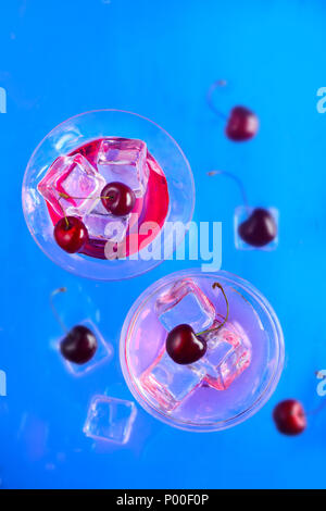 Verres à Cocktail cidre cerise à partir de ci-dessus, sur un fond bleu. Boisson fraîche mise à plat avec copie espace Banque D'Images
