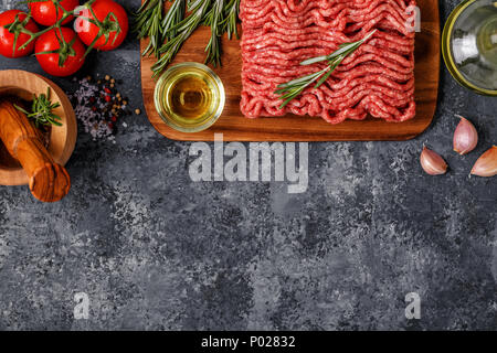 La viande hachée avec les épices, les herbes, l'huile d'olive, vue du dessus, copiez l'espace. Banque D'Images