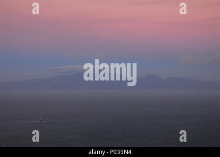 Un magnifique coucher de soleil colorés vue sur False Bay en Afrique du Sud. Remarque Le distant light house. Banque D'Images