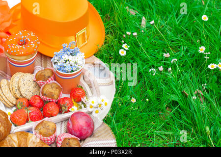 Pique-nique dans la célébration de la journée du roi. Déjeuner dans le jardin. De fruits et de pâtisseries. Chapeau Orange. Printemps dans les Pays-Bas. Texte et Carte postale Banque D'Images