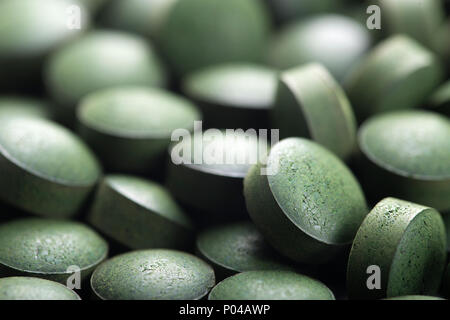 Algues bleu-vert. Close up de matière organique naturelle la spiruline comprimés avec l'accent à l'avant-plan et de l'effet de flou Banque D'Images