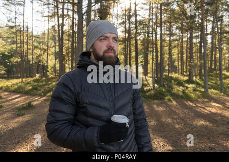 Portrait homme barbu avec tasse de café à emporter la marche dans la forêt et bénéficie d''intimité. Prenez une pause concept Banque D'Images