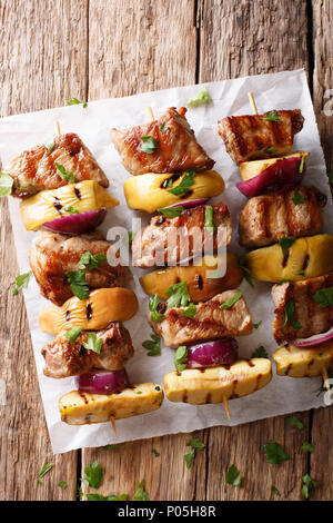 Brochettes de porc grillé avec des pommes fraîches et oignons rouges sur les brochettes, gros plan sur la table. Haut Vertical Vue de dessus Banque D'Images