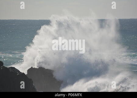 Explosion de surf sauvage à Sawtell, une vague s'écrasant contre les rochers envoie une masse de pulvérisation de mer et d'eau, horizon en arrière-plan, NSW Australie Banque D'Images