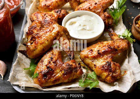 Ailes de poulet frit avec sauce blanche, vue en gros plan. Banque D'Images