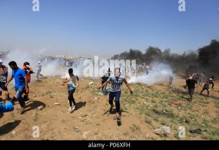 La ville de Gaza, bande de Gaza, territoire palestinien. 8 juin, 2018. Des manifestants palestiniens Run for Cover de gaz lacrymogène tiré par les forces de sécurité israéliennes au cours d'une manifestation marquant la Journée, al-Quds (Journée de Jérusalem), à l'Israel-Gaza frontière dans l'Est de la ville de Gaza, le 8 juin 2018 : Crédit Dawoud Alkas Abo/APA/Images/fil ZUMA Alamy Live News Banque D'Images