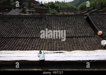 (180609) -- DANZHAI, le 9 juin 2018 (Xinhua) -- Une femme de l'ethnie miao chiffon sec pour faire des produits de batik Yangwu Ville de Danzhai County, au sud-ouest de la province du Guizhou, en Chine, le 8 juin 2018. Le peuple Miao artisanat batik est l'un des patrimoines immatériels nationaux de la Chine. Comme le principal site de l'héritage du peuple Miao Miao artisanat batik, la Jijia Village de Yangwu ville a un bon nombre d'excellents artisans, mais le trafic gênant avaient empêché la vente de produits de batik vers l'extérieur avant 2017. Avec l'augmentation de l'amélioration de la circulation et l'aide du gouvernement local et volu Banque D'Images