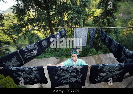 (180609) -- DANZHAI, le 9 juin 2018 (Xinhua) -- Une femme de l'ethnie miao batik séchant produits dans Yangwu Ville de Danzhai County, au sud-ouest de la province du Guizhou, en Chine, le 8 juin 2018. Le peuple Miao artisanat batik est l'un des patrimoines immatériels nationaux de la Chine. Comme le principal site de l'héritage du peuple Miao Miao artisanat batik, la Jijia Village de Yangwu ville a un bon nombre d'excellents artisans, mais le trafic gênant avaient empêché la vente de produits de batik vers l'extérieur avant 2017. Avec l'augmentation de l'amélioration de la circulation et l'aide du gouvernement local et des bénévoles depuis 2017 Banque D'Images