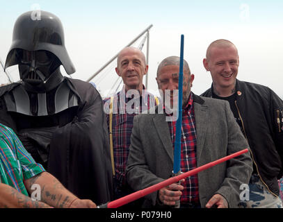 Un artiste de rue, habillé en Dark Vador rencontre quelques skinheads à Brighton Banque D'Images