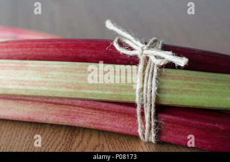 Close-up of fresh rhubarb vert et rouge avec une corde enroulée Vue de côté. Banque D'Images