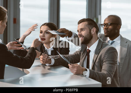 Groupe de businesspeople having argument avec réceptionniste airport Banque D'Images