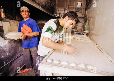 Erbil, le gouvernorat d'Erbil, Kurdistan irakien : boulangers pain plat cook à un four traditionnel dans la vieille ville d'Erbil. Banque D'Images