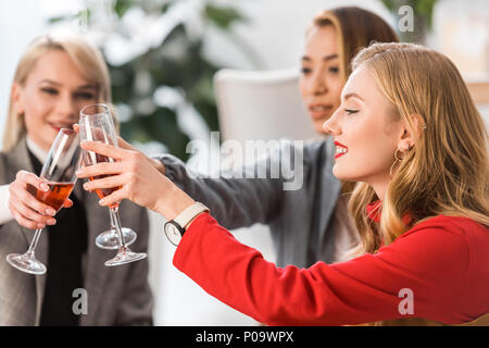 Succès d'affaires à la mode de trinquer avec verres de champagne in modern office Banque D'Images