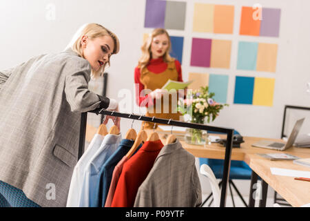 Éditeurs de magazines à la mode avec des vêtements de travail in modern office Banque D'Images