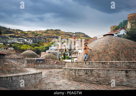 Belle Femme au chapeau brun et veste près de la coupole de l'acide sulfurique baignoire, dans le centre de Tbilissi, Géorgie Banque D'Images