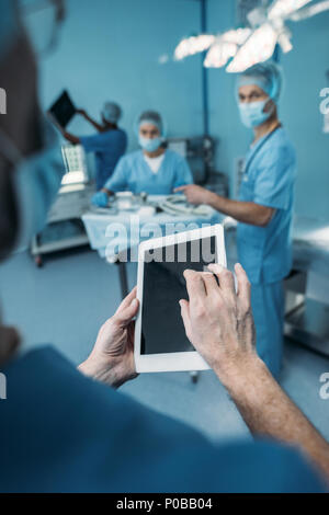 Portrait du médecin à l'aide de tablette en salle d'opération Banque D'Images